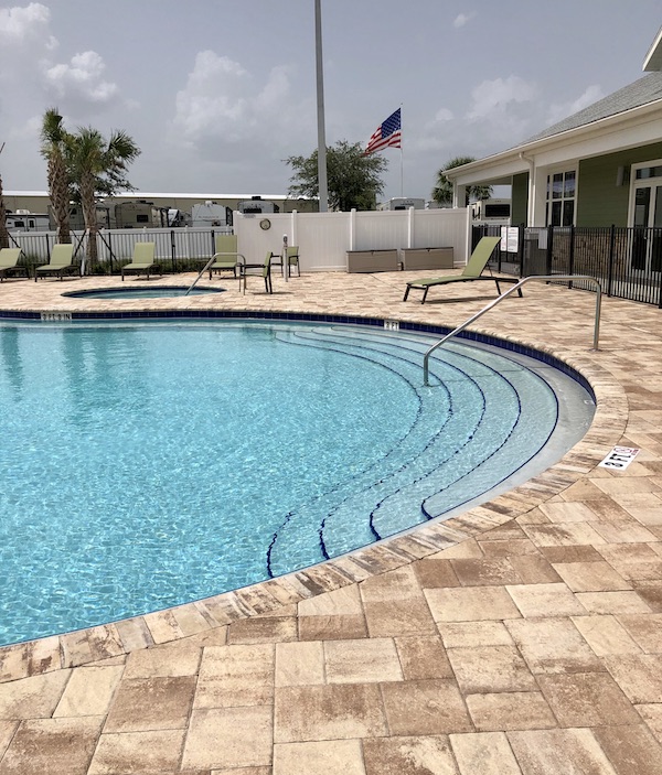 A swimming pool with paver patio at Sunkissed Village RV Resort