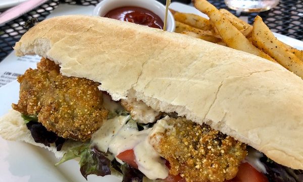 A white rectangular plate topped with a fried oyster hoagie and french fries at Hoppin' Johnz in Elizabeth City NC
