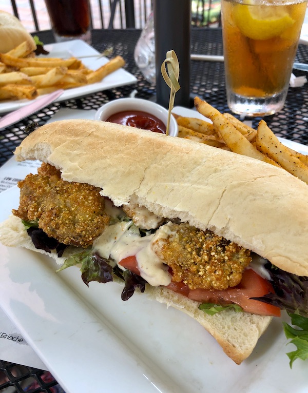 A white rectangular plate topped with a fried oyster hoagie and french fries at Hoppin' Johnz in Elizabeth City NC