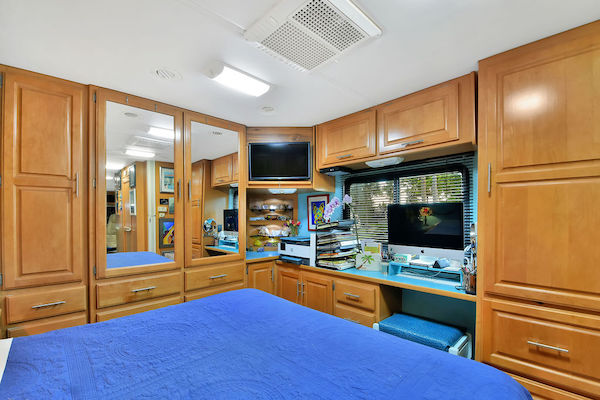 An RV bedroom with computer desk from RV Renovations Complete The Big Reveal