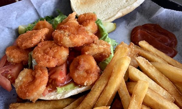 A platter with a toasted burger bun topped with fried shrimp and a side of fries at Sanitary Restaurant, Morehead City, NC