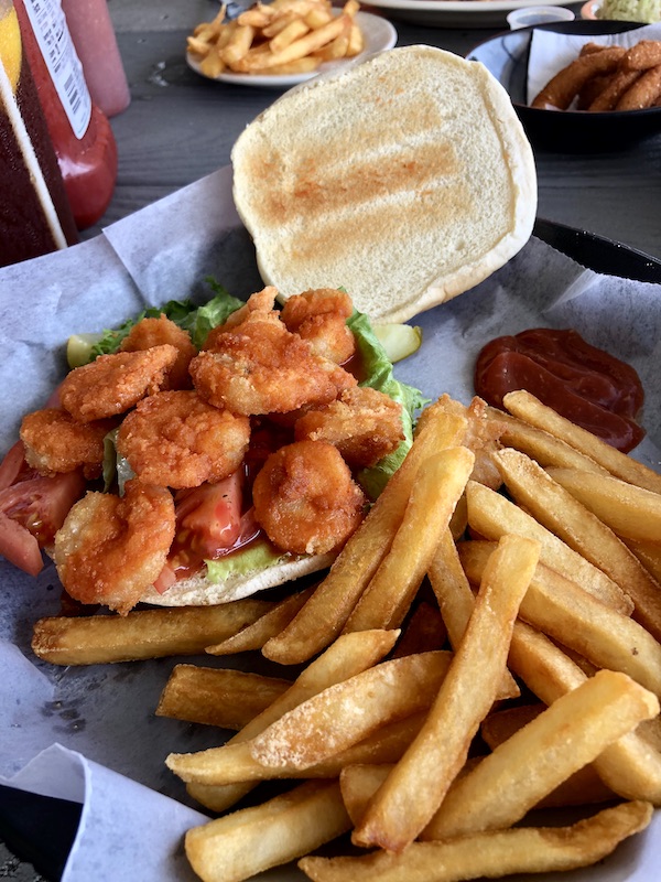 A platter with a toasted burger bun topped with fried shrimp and a side of fries at Sanitary Restaurant, Morehead City, NC