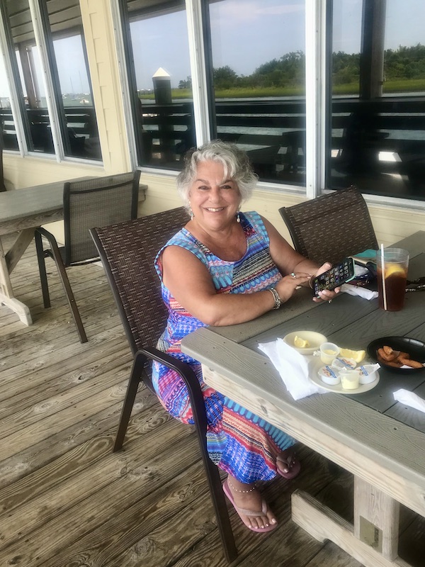 A woman with silver hair seated at an outdoor restaurant Sanitary Restaurant, Morehead City, NC