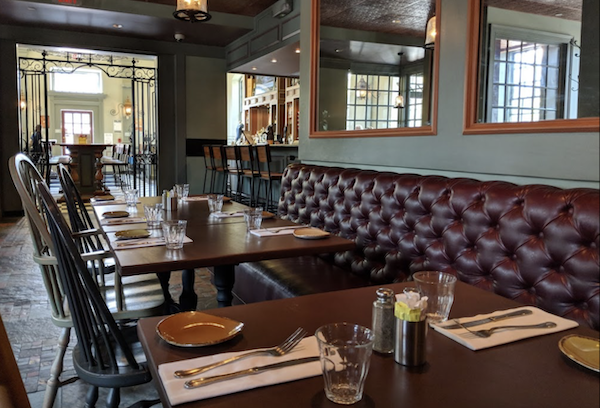 The interior of an old pub with tufted leather banquette in Williamsburg Virginia