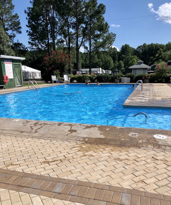A large L shaped pool surrounded by pavers in Williamsburg Virginia