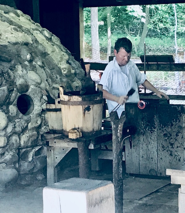 A man making a glass vessel as in the 1600s in Williamsburg Virginia