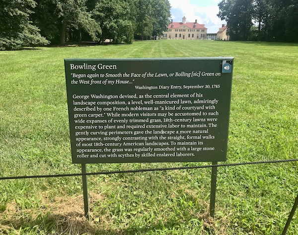 A sign, lawn and trees with George Washington's Mount Vernon in the distance