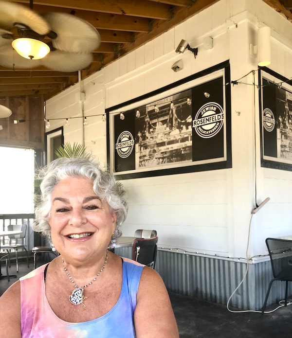 A woman in a tie dye dress sitting in a restaurant at Maryland and Virginia Beaches