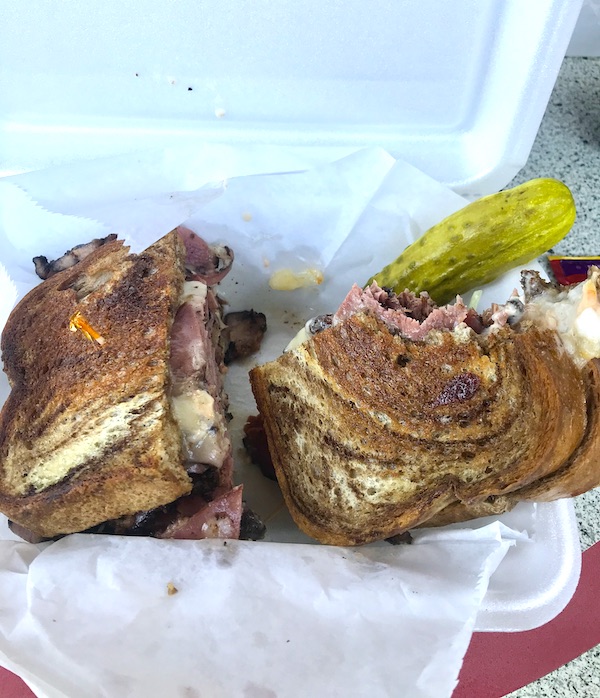 At Maryland and Virginia Beaches a grilled sandwich in a white styrofoam clamshell with pickle