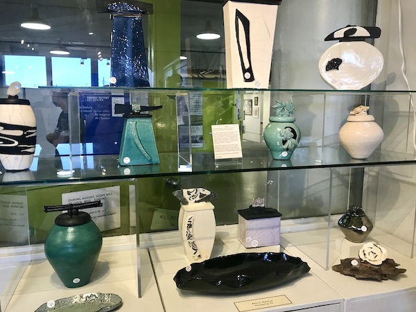 Glass shelving with a variety of ceramic art displayed at The Torpedo Factory Alexandria Virginia