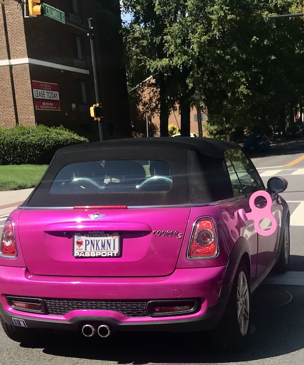 A fuchsia car with a black soft top and wind up key on the street near The Torpedo Factory Alexandria Virginia