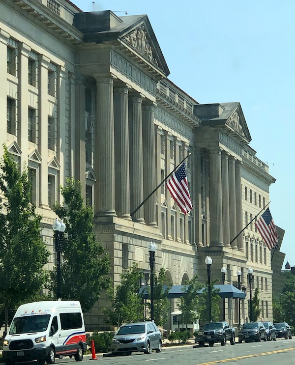 A tan building with trees and vehicles in front in Washington DC and Annapolis Maryland