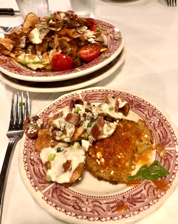Dark red and white plates topped with Fried Green Tomatoes and blue cheese covered potato chips in Atlanta Georgia