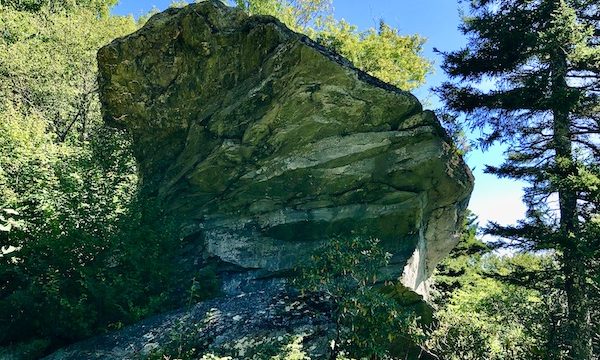 A fan shaped rock with trees and blue sky along the Blue Ridge Parkway NC