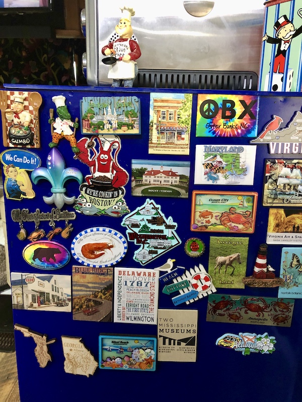 A blue surface with a collection of souvenir magnets from Boone North Carolina