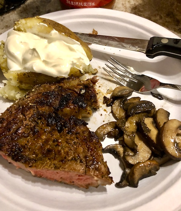 A white plate topped with steak, mushrooms and baked potato with sour cream at Delaware Seashore State Park