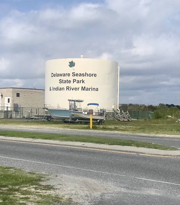 A large white sign wall with the words Delaware Seashore State Park and Indian River Marina