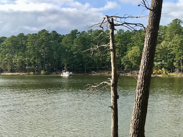A lake with trees and a white boat at Jordan Lakes State Park