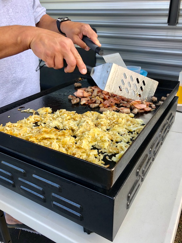 A chef preparing breakfast on a flat top at Kiptopeke State Park in Virginia