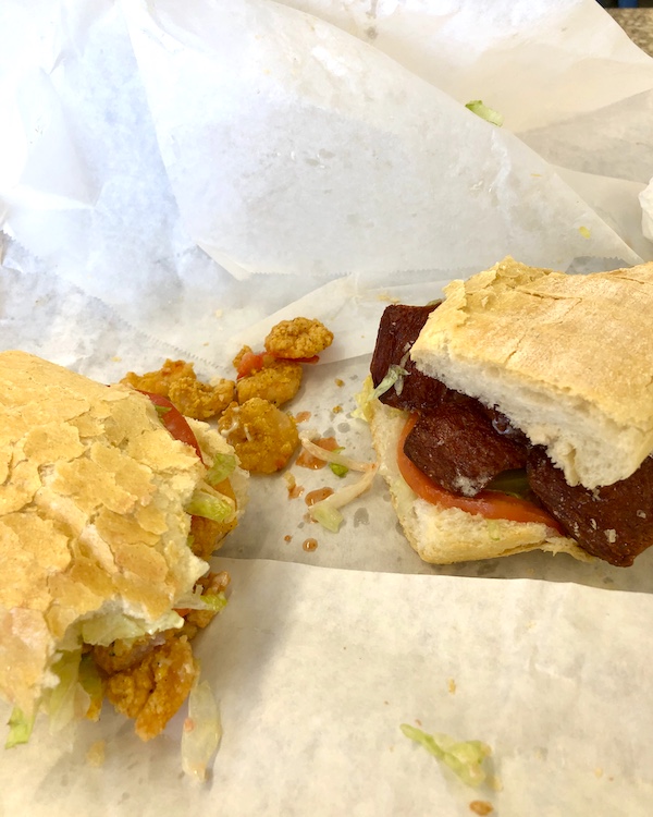 Partially eaten shrimp and sausage sandwiches on white deli paper in LaPlace Louisiana