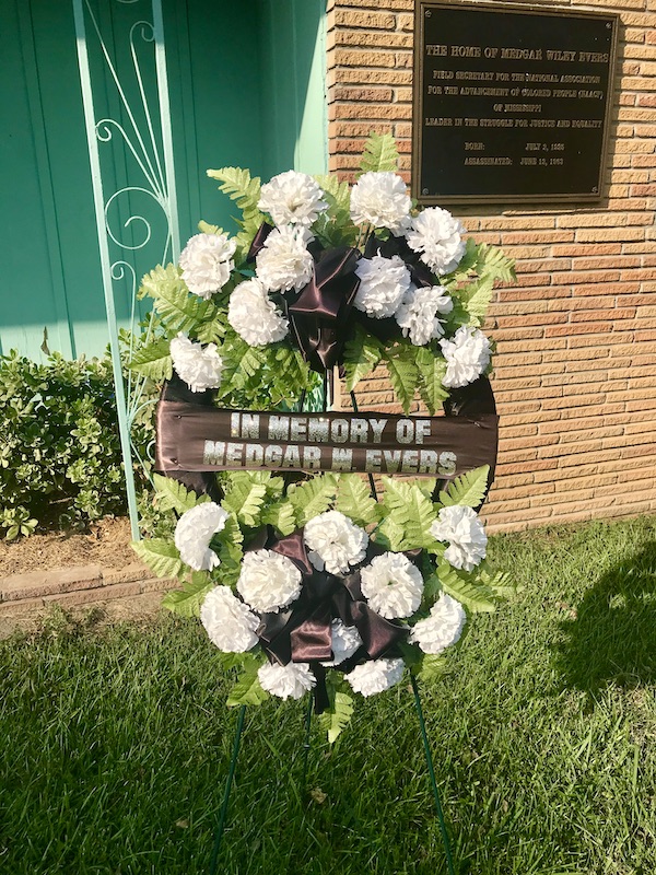 A funeral wreath of white flowers on a front lawn of a home near the Mississippi Civil Rights Museum