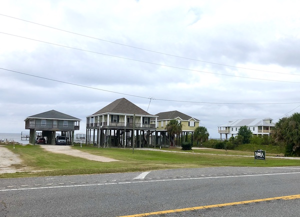 A cluster of stilt homes with lawn in front and water in back along our route from NOLA to Biloxi