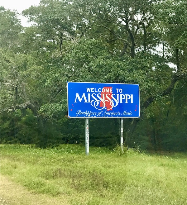 A blue sign with white writing Welcome to Mississippi along our drive from NOLA to Biloxi