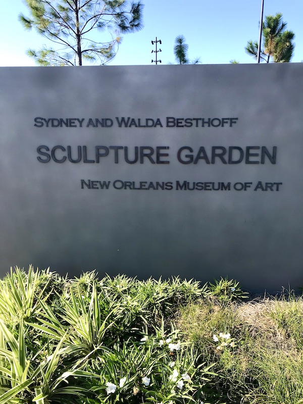 A gray stone wall announcing the Besthoff Sculpture Garden at New Orleans City Park
