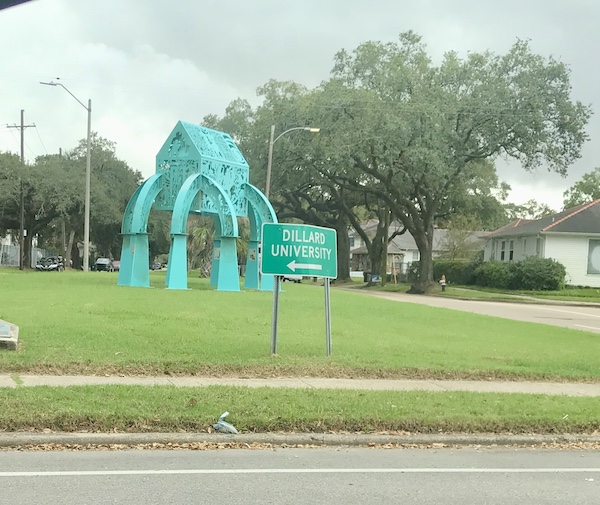 An aqua metal sculpture of a stilt house on the lawn at New Orleans City Park