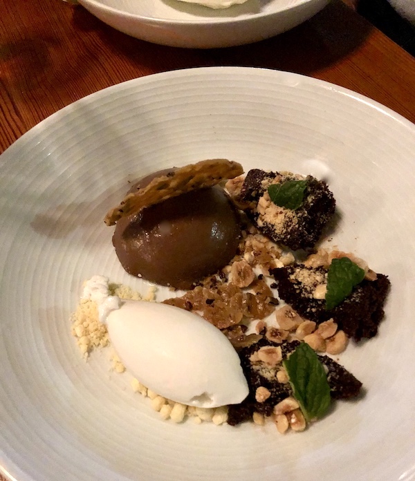 A white plate topped with scoops of brown and white ice cream and chopped nuts at Revisiting Bywater American Bistro