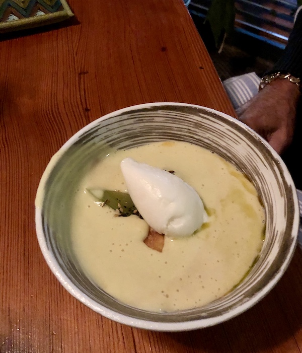 A beige and brown bowl filled with a cream colored soup with a scoop of white sorbet in the middle at Revisiting Bywater American Bistro