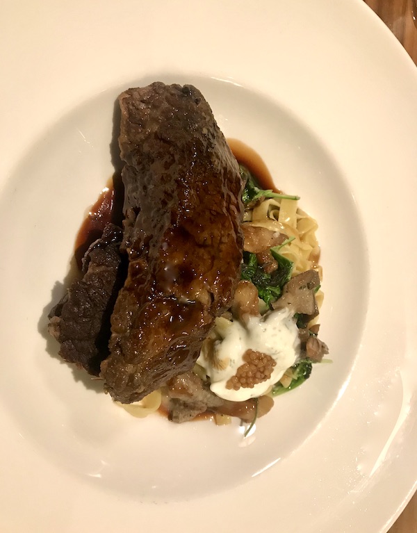 Beef short rib with noodles and mushrooms on a white plate at Sue Zemanick's Zasu