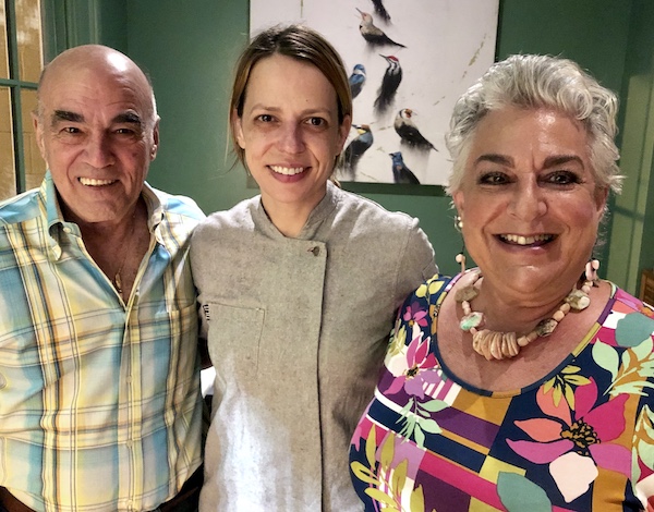 A woman in a gray chef coat flanked by a man and a woman at Sue Zemanick's Zasu
