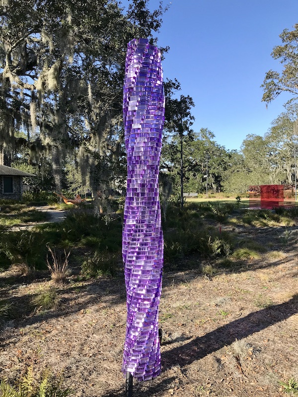 An amethyst glass tower sculpture at the Bestoff Sculpture Garden