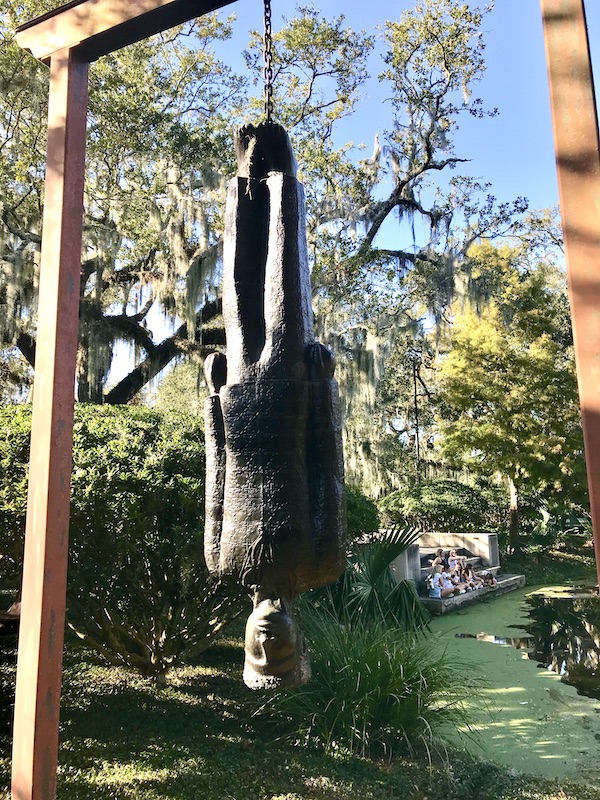 A bronze sculpture of a man hanging upside down at the Bestoff Sculpture Garden