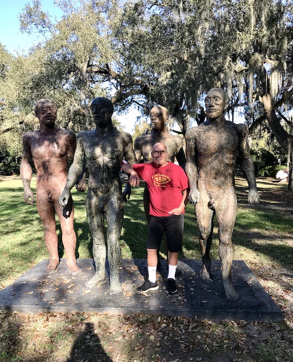 A sculpture of 4 warriors and a man in a red tee shirt at the Bestoff Sculpture Garden