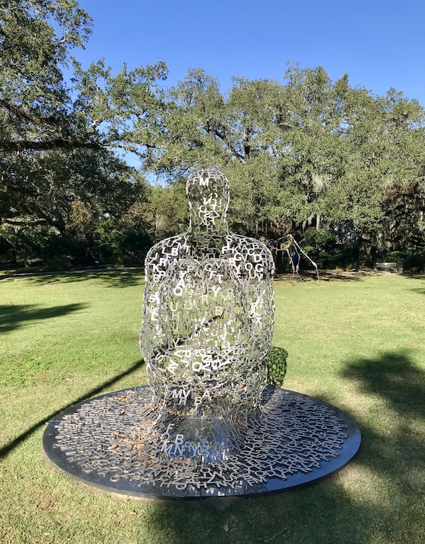 A steel sculpture of a seated person made of letters at the Bestoff Sculpture Garden