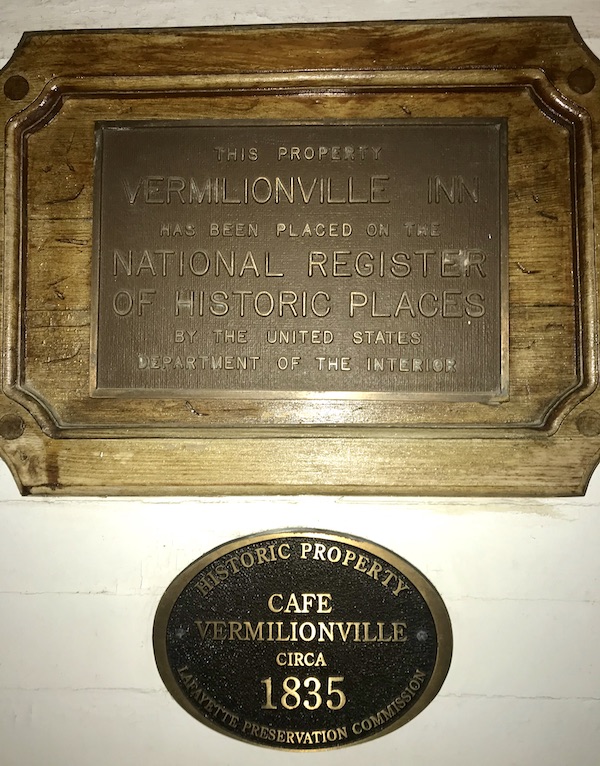 One brass and one bronze plaque designating the historic status of Café Vermillionville Lafayette Louisiana