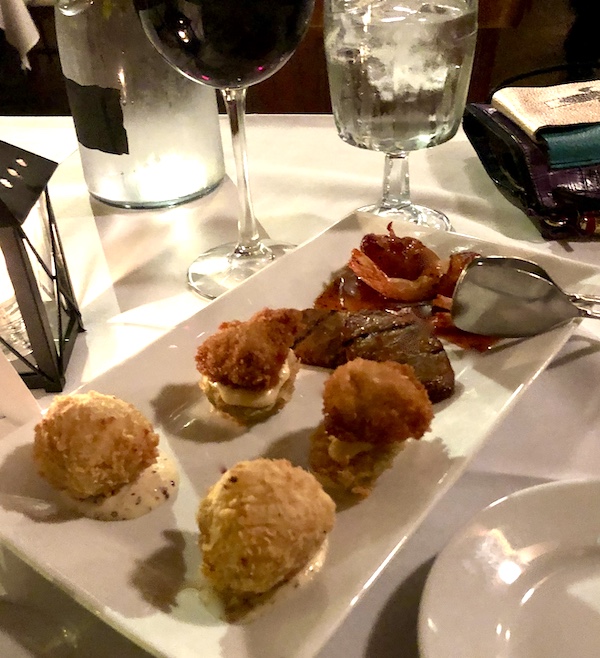 A white rectangular platter topped with pairs of appetizers at Café Vermillionville Lafayette Louisiana