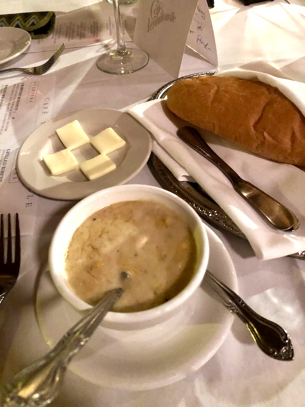 A bowl of creamy soup, a napkin lined basket of bread and a plate of butter at Café Vermillionville Lafayette Louisiana