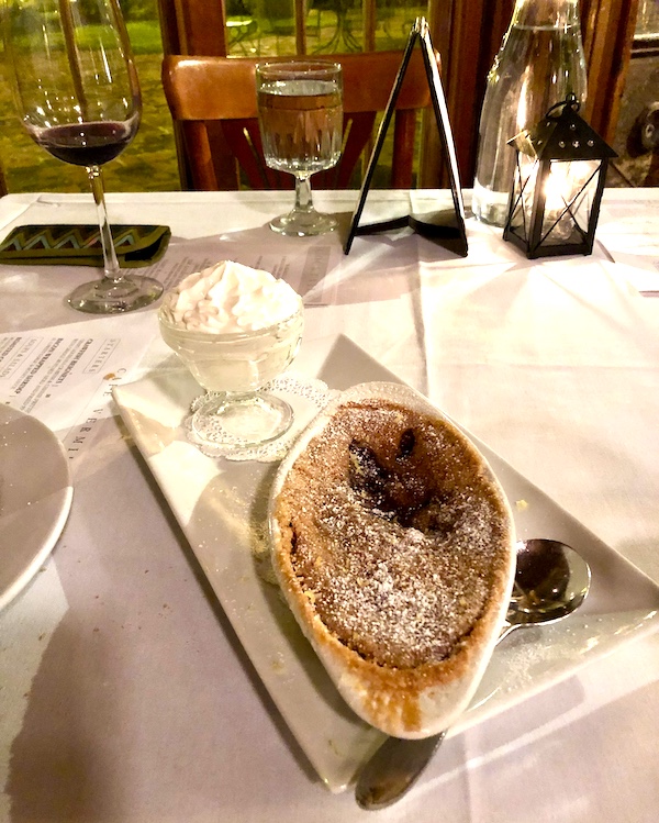 A rectangular white platter topped with an oval dish of creme brulee and a dish of whipped cream at Café Vermillionville Lafayette Louisiana