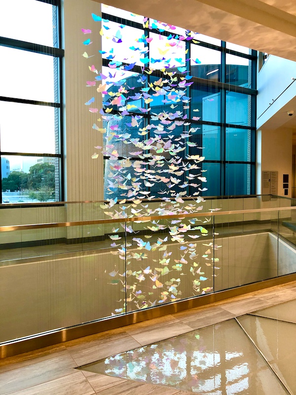 Hundreds of butterflies hang in front of windows at the Holocaust Museum Houston