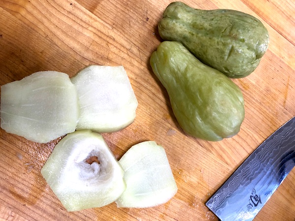 Seasonal Ingredient Mirliton, two whole and one cut into thick slices.