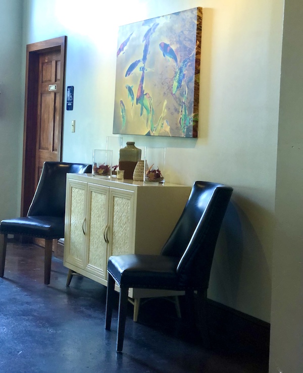A yellow room with cabinet and two chairs