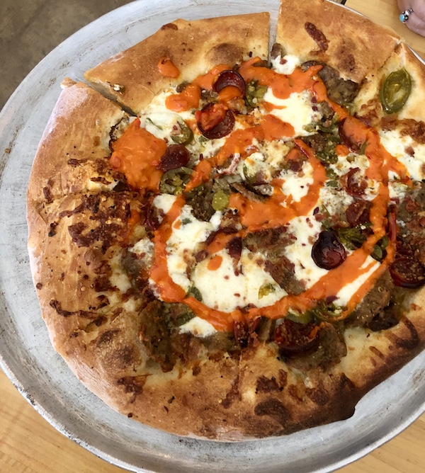 A pizza topped with meatballs, peppers and cheese in Southwestern Louisiana