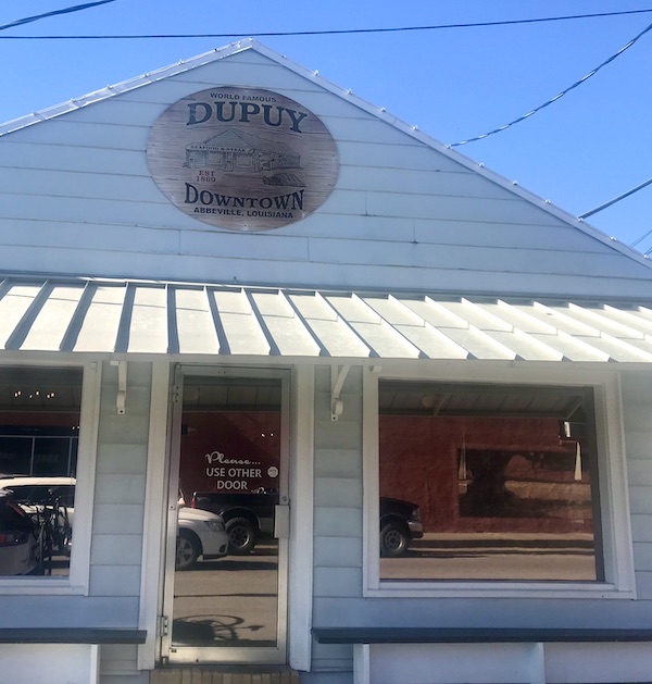 The front of a grey building with an awning in Southwestern Louisiana