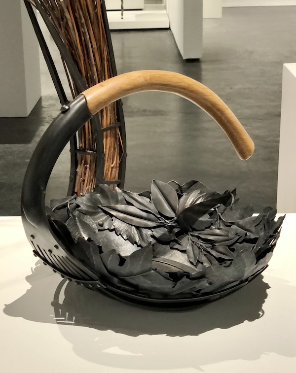 A steel basket with wood handle at The Houston Center for Contemporary Craft