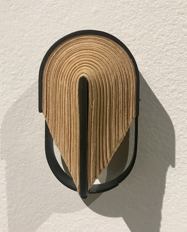 An oval wall art of steel and book paper at The Houston Center for Contemporary Craft