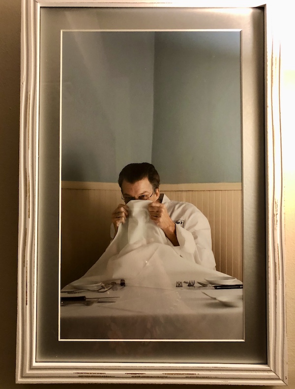Tidbits of Life in New Orleans a portrait of a chef peeking out behind a tablecloth