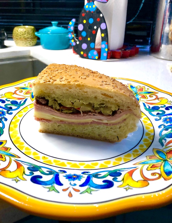 Tidbits of Life in New Orleans a colorful plate topped with a wedge of a deli sandwich.